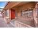 Inviting front porch with red door, brick detail, and covered entry at 18736 E Powers Pl, Aurora, CO 80015