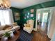 Inviting living room with rich green walls, plush seating, and abundant natural light from adjacent room at 421 E Alameda Ave, Denver, CO 80209