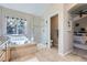 Bright bathroom featuring a bathtub, tiled shower, and natural light from the window at 10273 Bentwood Ln, Highlands Ranch, CO 80126