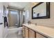 Bright bathroom featuring a shower-tub combination and a wood vanity with a framed mirror at 10273 Bentwood Ln, Highlands Ranch, CO 80126
