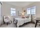 Cozy bedroom with a black metal bed frame, plush pillows, and two windows offering natural light at 10273 Bentwood Ln, Highlands Ranch, CO 80126