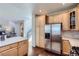 Open kitchen with stainless steel fridge, updated cabinets, and hardwood floors at 10273 Bentwood Ln, Highlands Ranch, CO 80126