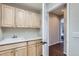Convenient mudroom area with ample cabinetry and a sink, leading to hallway with hardwood floors at 10273 Bentwood Ln, Highlands Ranch, CO 80126