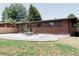 Brick home featuring a modern design, a well-manicured lawn and a spacious patio at 5882 W Chestnut Ave, Littleton, CO 80128