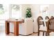 Sunlit dining area with a sleek wood table, upholstered chairs, and a view to the outdoors at 5882 W Chestnut Ave, Littleton, CO 80128