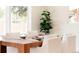 Bright dining area featuring hardwood floors, a wood table, and a healthy green houseplant at 5882 W Chestnut Ave, Littleton, CO 80128