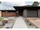 A modern single-story home featuring stylish gray tones, red brick, and a well-lit entrance at 5882 W Chestnut Ave, Littleton, CO 80128