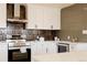 Bright modern kitchen with white cabinets, stainless steel appliances, and eye-catching vertical tile backsplash at 5882 W Chestnut Ave, Littleton, CO 80128