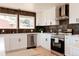 Bright eat-in kitchen features white cabinets, stainless appliances, dark backsplash, and an island with barstool seating at 5882 W Chestnut Ave, Littleton, CO 80128