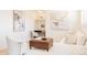 Bright living room area with neutral-toned furniture, a stylish painting on the wall, and a small desk nook at 5882 W Chestnut Ave, Littleton, CO 80128