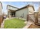 Spacious backyard featuring artificial turf and a covered patio with an outdoor fireplace at 6723 Raritan Dr, Denver, CO 80221
