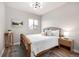 A cozy bedroom includes a wooden bedframe, natural light from a window, and modern decor for a comfortable atmosphere at 6723 Raritan Dr, Denver, CO 80221