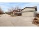 Detached two-car garage with a wide driveway providing ample parking space at 6723 Raritan Dr, Denver, CO 80221