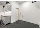 Organized garage space with storage cabinets, a workbench, epoxy floor and a separate entry door at 6723 Raritan Dr, Denver, CO 80221