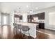 Gourmet kitchen featuring large island, pendant lighting, stainless appliances, and sleek dark cabinetry at 6723 Raritan Dr, Denver, CO 80221