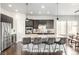 Contemporary kitchen featuring stainless steel appliances, a large island with bar seating, and dark wood cabinetry at 6723 Raritan Dr, Denver, CO 80221