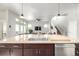 Open concept kitchen features island with sink overlooking living area and hardwood flooring at 6723 Raritan Dr, Denver, CO 80221