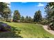 Expansive backyard featuring a lush lawn, mature trees, and a serene setting at 69 N Ranch Rd, Littleton, CO 80127