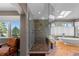 Modern main bathroom featuring a frameless shower, freestanding tub, and scenic view at 69 N Ranch Rd, Littleton, CO 80127