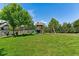 Expansive backyard featuring a well-maintained lawn, mature trees, and a charming wooden playset at 16267 W 59Th Pl, Golden, CO 80403