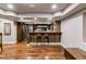 Stylish basement bar area with unique wood paneling, modern stools and stainless appliances at 16267 W 59Th Pl, Golden, CO 80403