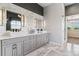 Bright bathroom featuring marble floors, double sinks with white countertops, and modern fixtures at 16267 W 59Th Pl, Golden, CO 80403