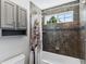 Bathroom featuring a shower-tub combo with neutral colored tile and storage at 16267 W 59Th Pl, Golden, CO 80403