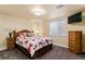 Cozy bedroom featuring a decorative bed, a wooden dresser, with large windows and neutral colored walls at 16267 W 59Th Pl, Golden, CO 80403