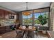 A sunlit dining area features a wooden table with seating, next to large windows offering outdoor views at 16267 W 59Th Pl, Golden, CO 80403