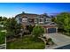 Beautiful two-story home with a well-manicured lawn and mature trees at dusk at 16267 W 59Th Pl, Golden, CO 80403