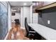 Hallway with hardwood floors leading to a basement area with decorative chalkboard, and a modern desk at 16267 W 59Th Pl, Golden, CO 80403