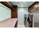 A well-organized laundry room featuring modern washer and dryer units with ample storage space and countertop at 16267 W 59Th Pl, Golden, CO 80403