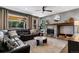 Comfortable living room features a stone fireplace, leather seating, and large windows overlooking the backyard at 16267 W 59Th Pl, Golden, CO 80403