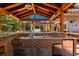 An outdoor kitchen area with stainless steel appliances, sink, ice maker, and brick siding at 16267 W 59Th Pl, Golden, CO 80403
