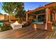 Relaxing outdoor retreat with hot tub, fireplace, seating and wooden deck surrounded by lush landscaping at 16267 W 59Th Pl, Golden, CO 80403