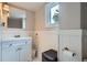 Small bathroom with a white vanity, wood paneling and accent mirror at 3655 Zenobia St, Denver, CO 80212