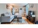 Open living area featuring hardwood floors, a gray sofa, and a view into the kitchen at 3655 Zenobia St, Denver, CO 80212