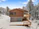 Home exterior with a balcony and outdoor living space surrounded by snow covered trees at 342 Brook Cir, Boulder, CO 80302