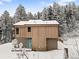 Two story home featuring wood siding, a blue front door, and surrounded by snow-covered trees at 342 Brook Cir, Boulder, CO 80302