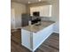 Bright kitchen features a granite countertop island, stainless steel refrigerator, and modern finishes at 7302 Arkansas Street, Frederick, CO 80530