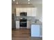Modern kitchen featuring stainless steel appliances, granite countertops, and sleek white cabinetry at 7302 Arkansas Street, Frederick, CO 80530