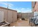 Small backyard area with a storage shed, wooden fence, and patio furniture under a clear blue sky at 9207 E Mansfield Ave, Denver, CO 80237