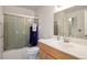 Functional bathroom features a glass-enclosed shower, vanity with ample counter space, and a wooden cabinet at 9207 E Mansfield Ave, Denver, CO 80237