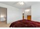 Bright bedroom featuring a ceiling fan, carpeted floor, and a glimpse into the adjacent bathroom at 9207 E Mansfield Ave, Denver, CO 80237
