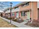 Charming townhome with a brick facade, sidewalk, and well-maintained landscaping creates a welcoming curb appeal at 9207 E Mansfield Ave, Denver, CO 80237