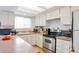 Cozy kitchen featuring modern appliances, a sink overlooking the yard, and ample storage at 9207 E Mansfield Ave, Denver, CO 80237