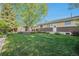 Wide backyard view shows sprawling green grass, deck and home exterior at 8626 W Utah Ave, Lakewood, CO 80232