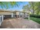 Backyard wooden deck, with lush landscaping and a brick-accented home at 8626 W Utah Ave, Lakewood, CO 80232