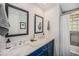Stylish bathroom featuring a double vanity with marble countertop and tiled shower with glass block window at 8626 W Utah Ave, Lakewood, CO 80232