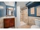 Inviting bathroom with dark blue walls, tiled shower and a wood vanity at 8626 W Utah Ave, Lakewood, CO 80232